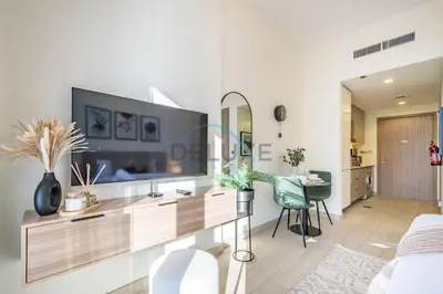 a living room with a large tv on a wall at Calming Studio Apartment at Azizi Riviera 4, Al Merkadh by Deluxe Holiday Homes in Dubai