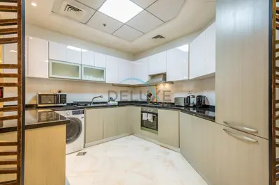 a large kitchen with white cabinets and a washer and dryer at Weekly Deal 3BR with Overlooking Canal & City Views by Deluxe Holiday Homes in Dubai