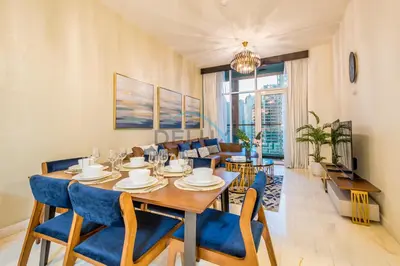 a dining room with a table and blue chairs at Stunning 3BR Apartment in Bayz Tower, Business Bay by Deluxe Holiday Homes in Dubai