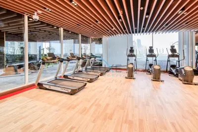 a gym with a row of treadmills and machines at Stunning 3BR Apartment in Bayz Tower, Business Bay by Deluxe Holiday Homes in Dubai