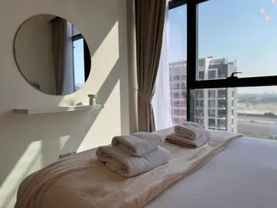a hotel room with towels on a bed with a mirror at ASHRI luxurious apt in Meydan Riviera 44 in Dubai