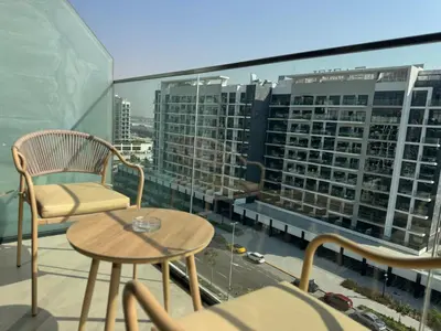 a balcony with a table and chairs and a view of a city at ASHRI luxurious apt in Meydan Riviera 44 in Dubai