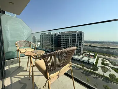a balcony with a table and chairs and a view of a city at ASHRI luxurious apt in Meydan Riviera 44 in Dubai