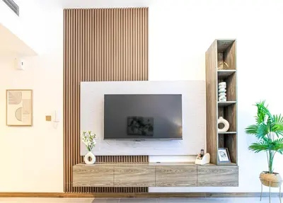 a living room with a television on a wall at 1BR Apt Residence Along Business Bay Canal in Dubai