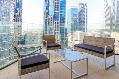 a balcony with two chairs and a glass table at 1BR Apt Residence Along Business Bay Canal in Dubai