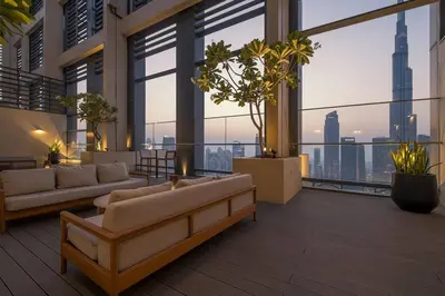 a living room with couches and a view of a city at Glow Sky Suite Trendy 1BR- Dubai Mall Access by Maxx Value Homes in Dubai