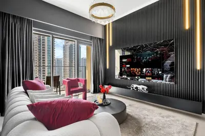 a living room with a white couch and pink pillows at Glow Sky Suite Trendy 1BR- Dubai Mall Access by Maxx Value Homes in Dubai