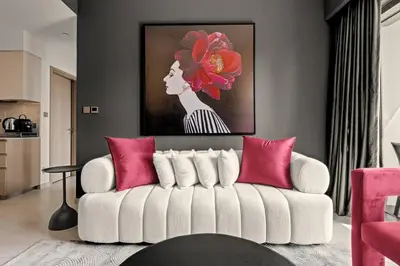 a living room with a white couch with pink pillows at Glow Sky Suite Trendy 1BR- Dubai Mall Access by Maxx Value Homes in Dubai