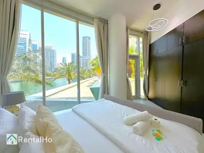 a bedroom with a white bed with a large window at Unforgettable View & Experience Over Dubai Canal in Dubai