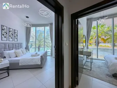 a bedroom with a bed and a desk and a window at Unforgettable View & Experience Over Dubai Canal in Dubai