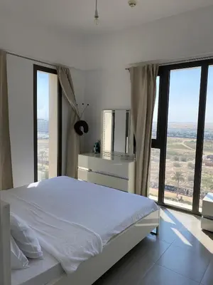 a bedroom with a white bed and large windows at Lovely calm 3BR Apt Easy Accessibility to central Dubai with huge balcony and pool view Town Square in Dubai