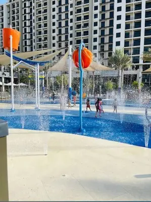 a water park with children playing in a fountain at Lovely calm 3BR Apt Easy Accessibility to central Dubai with huge balcony and pool view Town Square in Dubai