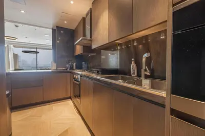 a kitchen with wooden cabinets and a sink and a window at FIVE Palm Residence - Elegant Home in Dubai