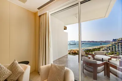 a room with a balcony with a view of the ocean at FIVE Palm Residence - Elegant Home in Dubai