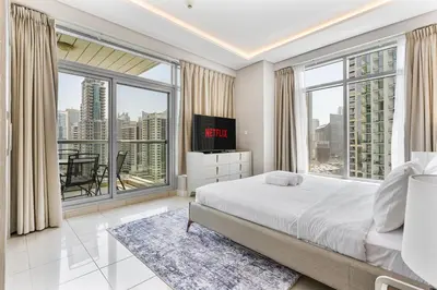 a bedroom with a large bed and large windows at Gorgeous 2BR APT in Dubai Marina with Canal View in Dubai