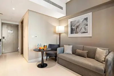 a living room with a couch and a table at Luxury Smart Studio with Canal View Business Bay - Damac Maison Prive in Dubai