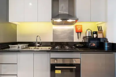a kitchen with a sink and a stove top oven at Luxury Smart Studio with Canal View Business Bay - Damac Maison Prive in Dubai