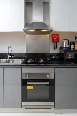 a kitchen with a stove and a sink at Luxury Smart Studio with Canal View Business Bay - Damac Maison Prive in Dubai