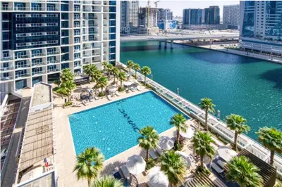 an overhead view of a pool with palm trees and buildings at Luxury Smart Studio with Canal View Business Bay - Damac Maison Prive in Dubai