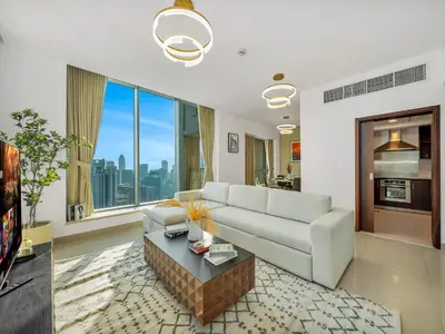 a living room with a white couch and a table at New Downtown Setup - Penthouse with Panoramaic Views in Dubai