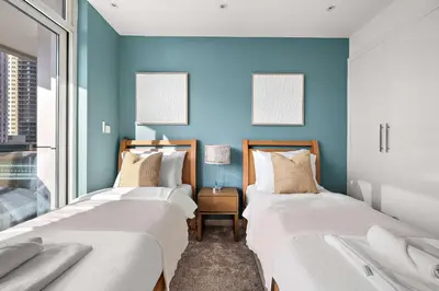 two beds in a room with blue walls at Silkhaus New and Stylish 2BR in Dubai Marina in Dubai