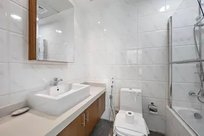a white bathroom with a sink and a toilet at Silkhaus New and Stylish 2BR in Dubai Marina in Dubai