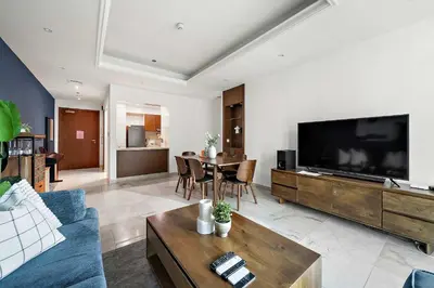 a living room with a blue couch and a tv at Silkhaus New and Stylish 2BR in Dubai Marina in Dubai