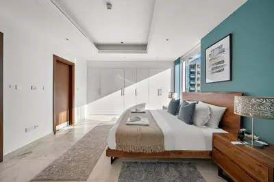 a bedroom with a large bed with blue walls at Silkhaus New and Stylish 2BR in Dubai Marina in Dubai
