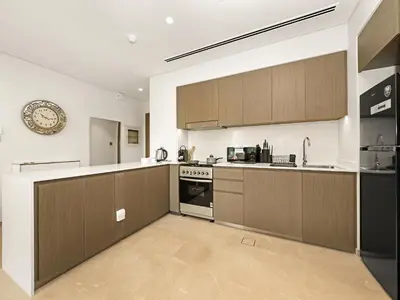 a kitchen with wooden cabinets and a stove top oven at Luxury 1BR 5min to Dubai Mall Burj Khalifa View from pool in Dubai