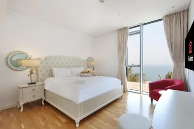 a bedroom with a white bed and a large window at Livbnb - Luxury 3B with Maid's Room, Partial Sea View in Dubai