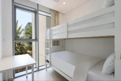 a bedroom with white bunk beds and a desk at Livbnb - Luxury 3B with Maid's Room, Partial Sea View in Dubai