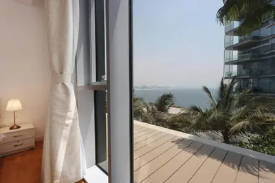 a room with a balcony with a view of the ocean at Livbnb - Luxury 3B with Maid's Room, Partial Sea View in Dubai