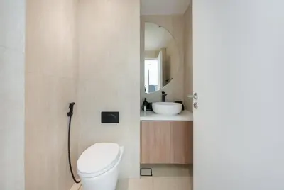 a bathroom with a toilet and a sink and a mirror at StayShort - Grand Stay in this 1 Bedroom Flat that Sleeps 4 in Dubai