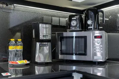 a kitchen counter with a coffee maker and a microwave at StayShort - Grand Stay in this 1 Bedroom Flat that Sleeps 4 in Dubai
