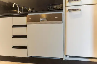 a kitchen with a dishwasher and a white refrigerator at StayShort - Grand Stay in this 1 Bedroom Flat that Sleeps 4 in Dubai