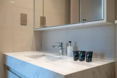 a kitchen counter with a sink and a mirror at Stylish Urban Living - 1-bedroom in Burj Royale in Dubai