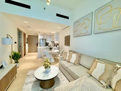 a living room with a couch and a table at Modern 1br In Jvc Pool, Balcony & Free Parking in Dubai