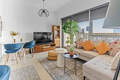 a living room with a couch and a table at Stylish 1BR with Iconic Burj and Fountain Views, Free Luxury Airport Pick Up Service in Dubai