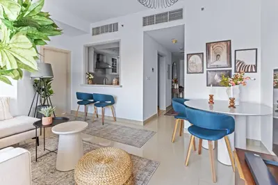 a living room with a table and chairs at Stylish 1BR with Iconic Burj and Fountain Views, Free Luxury Airport Pick Up Service in Dubai