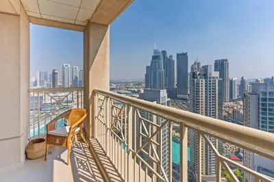 a balcony with a chair and a view of a city at Stylish 1BR with Iconic Burj and Fountain Views, Free Luxury Airport Pick Up Service in Dubai