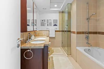 a bathroom with a sink and a tub and a shower at Stylish 1BR with Iconic Burj and Fountain Views, Free Luxury Airport Pick Up Service in Dubai