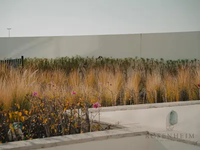 a field of flowers in front of a building at Modern Studio Escape - Pool, Gym & Relaxation in Dubai