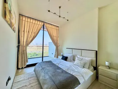 a bedroom with a large bed and a large window at Cozy & Stylish 1br Apt Jvc Pool & Parking in Dubai