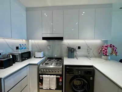 a kitchen with a stove and a washing machine at Cozy & Stylish 1br Apt Jvc Pool & Parking in Dubai