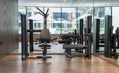 a gym with treadmills and exercise equipment in a building at Cozy & Stylish 1br Apt Jvc Pool & Parking in Dubai