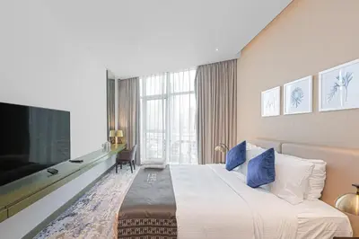 a hotel room with a bed and a large window at Escape24 Cozy Studio with Pool & Canal View near Burj Khalifa in Dubai