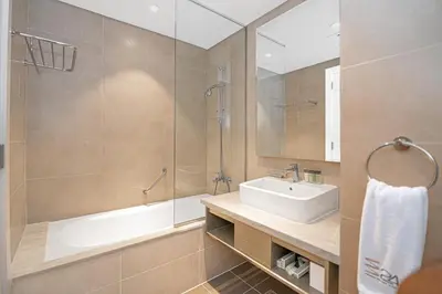 a bathroom with a sink and a shower and a tub at Escape24 Cozy Studio with Pool & Canal View near Burj Khalifa in Dubai