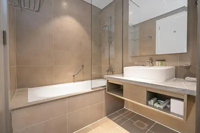 a bathroom with a sink and a shower and a tub at Escape24 Cozy Studio with Pool & Canal View near Burj Khalifa in Dubai