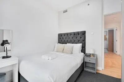 a bedroom with a large white bed with a black headboard at Urban Gem 2BR with Stunning Views in Dubai