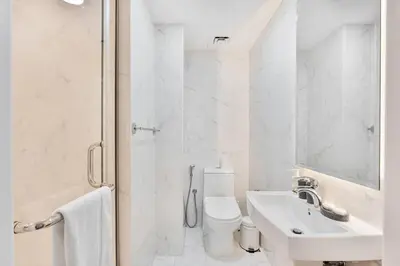 a white bathroom with a toilet and a sink at Urban Gem 2BR with Stunning Views in Dubai